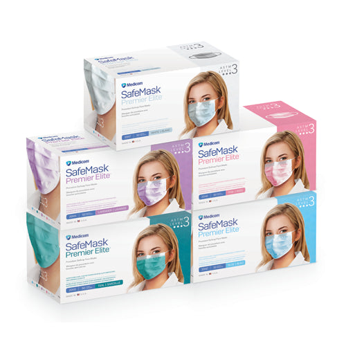 Five boxes of Medikom SafeMask Premier Elite Level 3 masks stacked in a pyramid arrangement on a white background. The boxes feature different color accents (purple, pink, teal, and blue) and show a model wearing the masks.