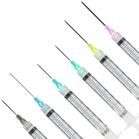 Five BD syringe-style needles with different colored tips (pink, yellow, green, blue, and gray) arranged diagonally on a plain white background.